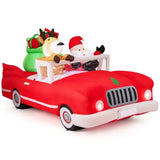 XXL Opblaasbare Kerstdecoratie - Tuin Decoratie - Santa Claus met Rendiervriend in Rood Auto - LED Verlichte Tuindecoratie - Inclusief Cadeauzak - Waterdicht en Weerbestendig Polyester - 9 Witte LED's - Met Bevestigingsset - Voor Buiten en Winterdecoratie